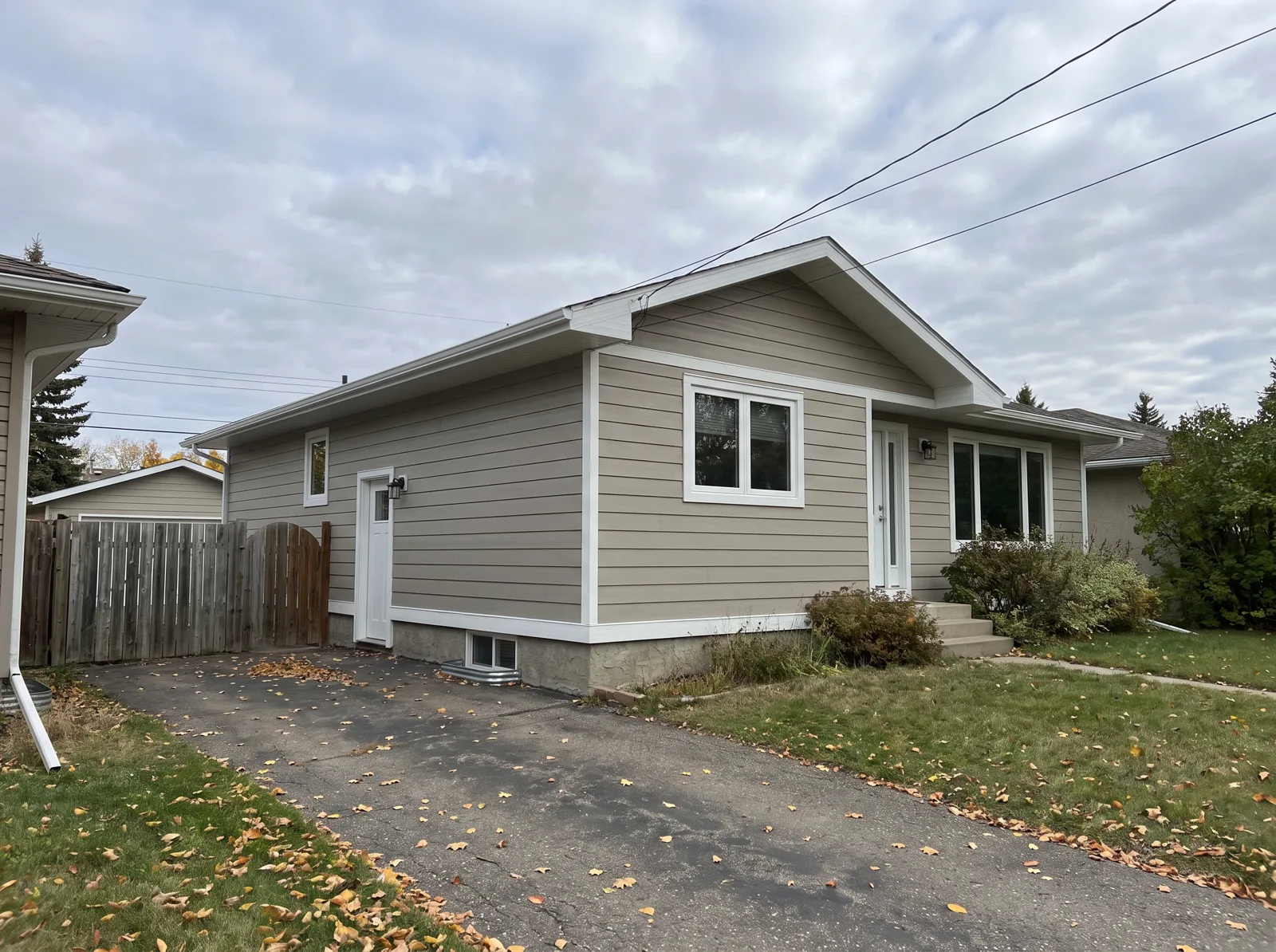 Freshly repainted two-storey home exterior with grey siding and crisp white trim