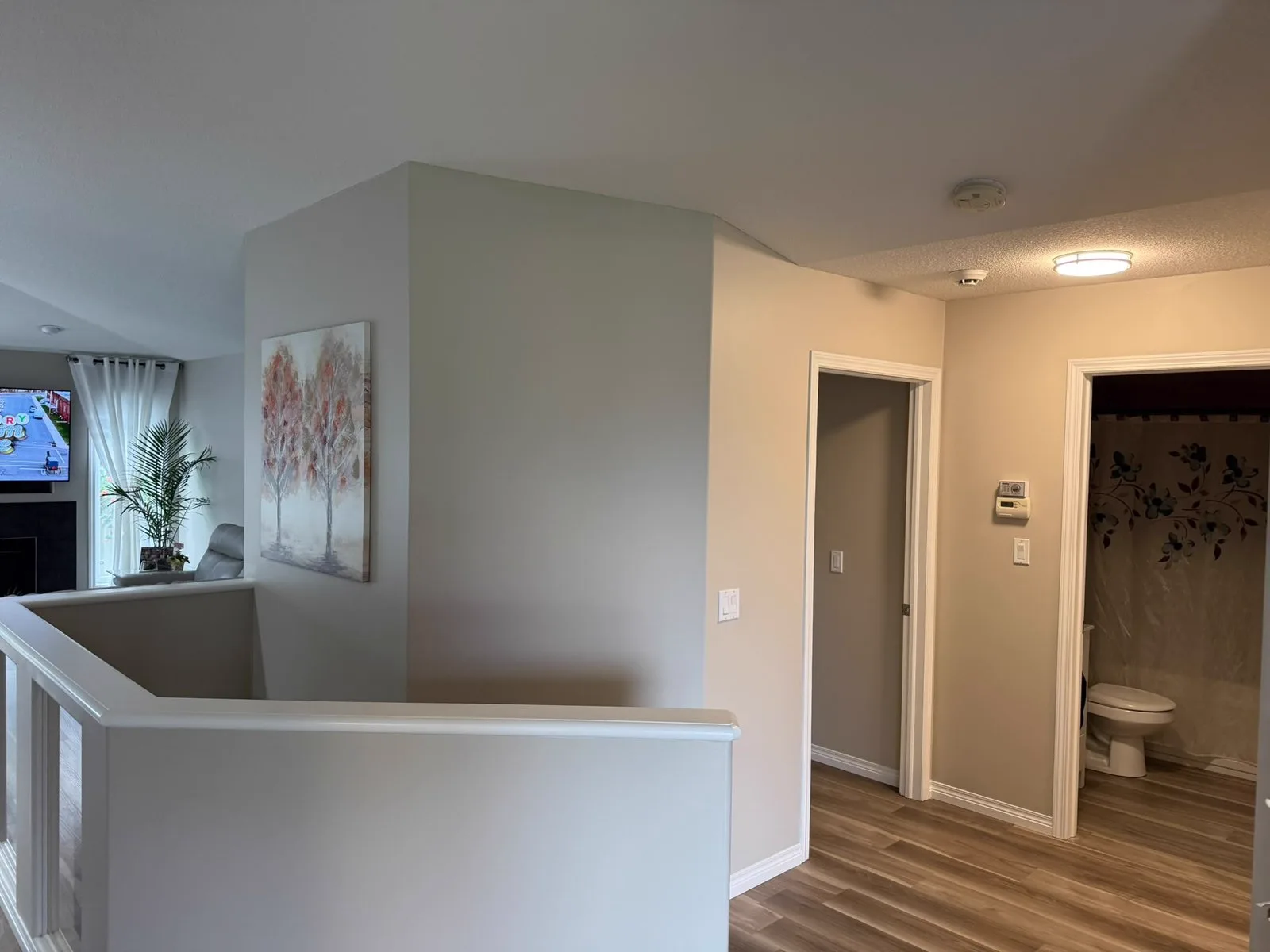 Hallway and stairwell repainted in a warm greige with white trim
